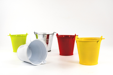 Multicolored small buckets  on a white background. table decorating item.の写真素材