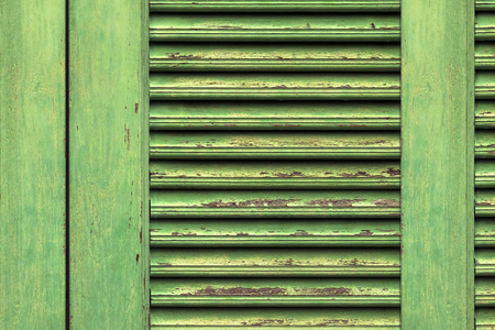 Wooden planks painted old green. Old painted wooden wall texture or background with copy space. Green window on old traditional houseの写真素材
