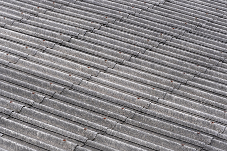 Pieces of old slate roofs covered with mold in the background. Abstract gray background with wavy textureの写真素材