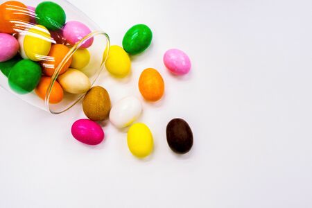 Colorful colored candy scattered from clear glass cups View background White background with text areaの写真素材