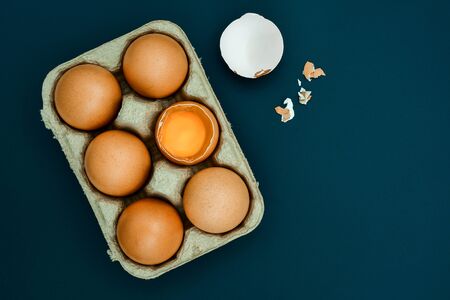 White egg and egg yolk in egg box on Light gray background, top view. With copy areaの写真素材