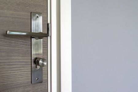 Brown door with stainless steel handles, unlocking the entrance.の写真素材