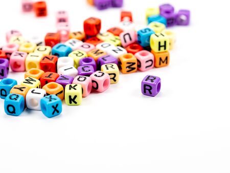 Colorful alphabets beads on white background, selective focus.  concept image
