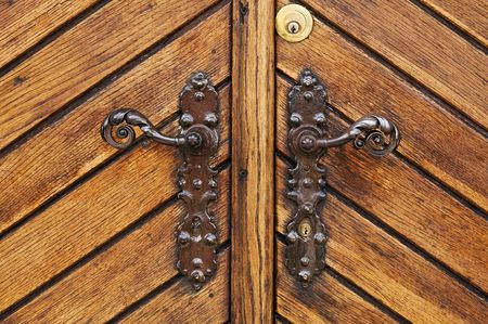 Double iron handle on a wooden doorの写真素材