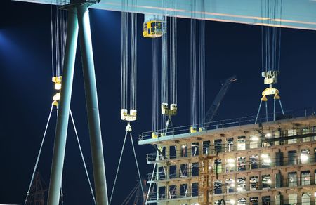 Detail of cranes and hooks in a shipyard by nightの写真素材