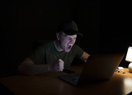Man works at a laptop at night