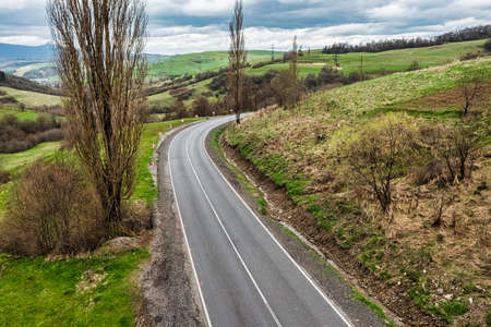 Aerial view of a narrow winding road, through the beautiful wooded Carpathians, amazing spring landscape, outdoor tourist background, Transcarpathia, Ukraineの写真素材