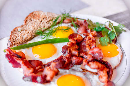 Tasty fried eggs, and crispy bacon, close-up, great classic breakfast. Macro photography, shallow depth of field.の写真素材