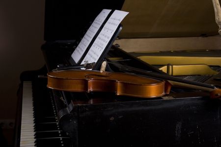 Violin on grand piano with notes sheetsの写真素材