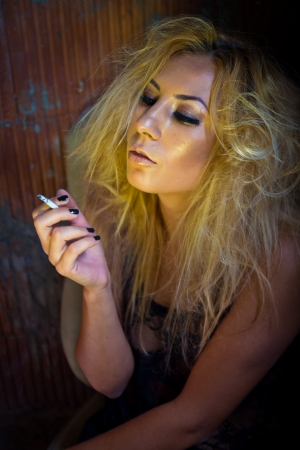 Woman smoking in a dark placeの写真素材