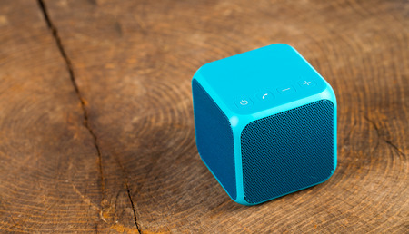 Blue bluetooth speaker cube on wood backgroundの写真素材