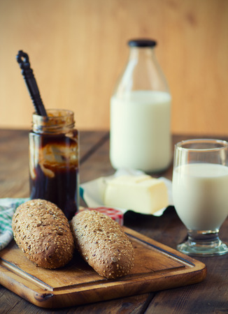 Rolls with a glass of milk on wooden tableの写真素材