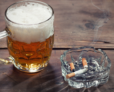 Pint of Beer and a lit cigaretteの写真素材