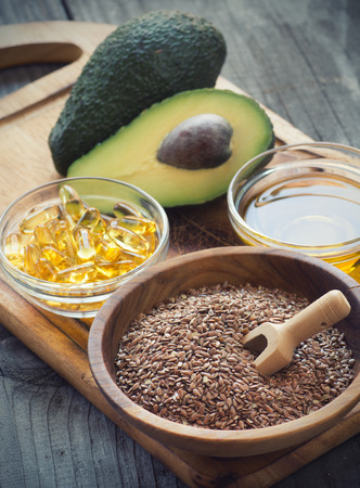 Sources of omega 3 fatty acids: flaxseeds, avocado, oil capsules and flaxseed oilの写真素材
