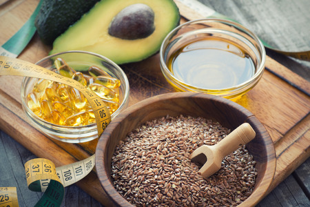 Sources of omega 3 fatty acids: flaxseeds, avocado, oil capsules and flaxseed oilの写真素材