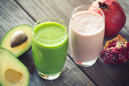 two fresh blended fruit smoothies made with avocado, pomegranateの写真素材