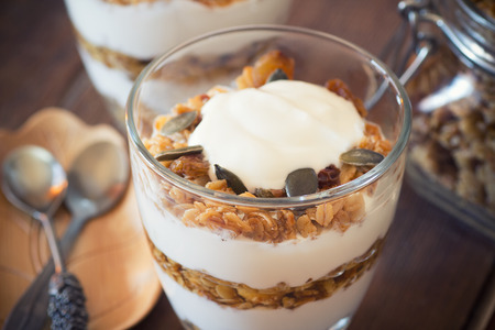 Healthy Breakfast - yogurt with homemade granola on the bright wooden boardの写真素材
