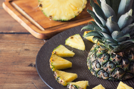 Pineapple fruit cut on wooden plateの写真素材