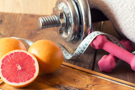 weight loss concept with tape measure organic grapefruit and dumbbellsの写真素材