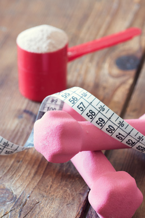 weight loss concept - with tape measure whey powder and pink dumbbellsの写真素材