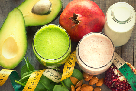 two fresh blended fruit smoothies made with avocado, pomegranate, spinach and almondsの写真素材
