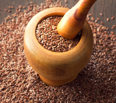 linseeds in mortar on wooden deskの写真素材