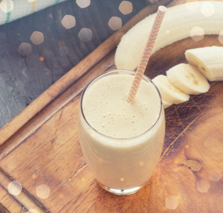 Banana smoothie on a rustic wooden tableの写真素材