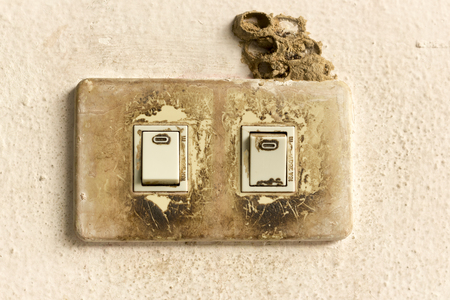 Old power switch on old wall.