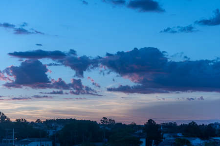 The colors of late afternoon and sunset in the city of Santa Maria, Brazil, in southern Latin America. Abstract colors and heavy clouds composing the sky at dusk.の写真素材