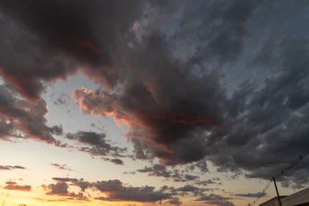 The colors of late afternoon and sunset in the city of Santa Maria, Brazil, in southern Latin America. Abstract colors and heavy clouds composing the sky at dusk.の写真素材