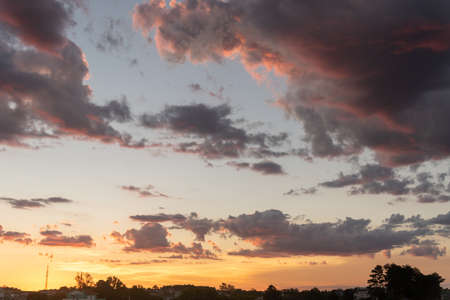 The colors of late afternoon and sunset in the city of Santa Maria, Brazil, in southern Latin America. Abstract colors and heavy clouds composing the sky at dusk.の写真素材