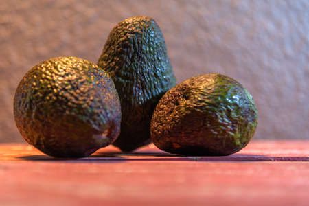 Avocado fruits. Persea americana) in its natural state. Stone fruit. Food consumed fresh and in salads. Whole avocado. Green and fresh avocados on the market stall.の写真素材