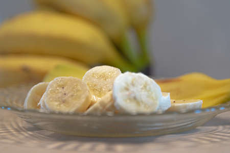 Bananas cut and served on a plate. Dessert with tropical fruit. Defocused banana fruits. Fruit made in brazil for export. Dwarf bananas served in slices.の写真素材