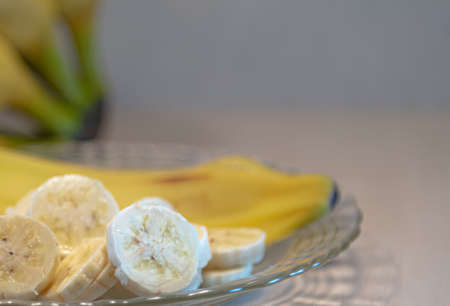 Bananas cut and served on a plate. Dessert with tropical fruit. Defocused banana fruits. Fruit made in brazil for export. Dwarf bananas served in slices.の写真素材