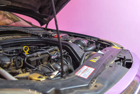 A car stopped in the garage with the hood open and the engine showing for home repairs. Combustion engine.の写真素材