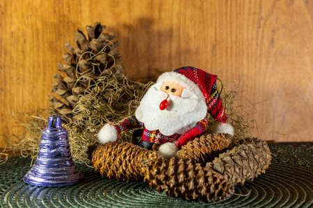 Decoration for Christmas Day where a Santa Claus appears among pine cones and other props that bring the Christmas Day motifs. Christian feast. Christmas decoration.の写真素材