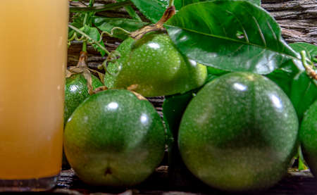 fresh and frozen passion fruit juice. Green fruits. Leaves on wooden background. healthy drink. tropical fruit cocktail. Refreshing drink. natural drink. fruit juice.の写真素材