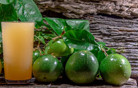 fresh and frozen passion fruit juice. Green fruits. Leaves on wooden background. healthy drink. tropical fruit cocktail. Refreshing drink. natural drink. fruit juice.の写真素材