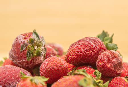 Frozen strawberries in close-up (Fragaria spp). frozen strawberries background. Fresh fruits covered with ice. Fruits arranged on a light background.の写真素材