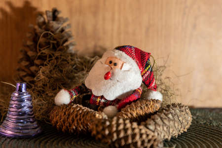 Decoration for Christmas Day where a Santa Claus appears among pine cones and other props that bring the Christmas Day motifs. Christian feast. Christmas decoration.の写真素材