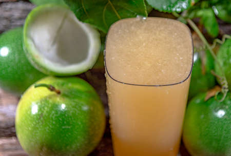 fresh and frozen passion fruit juice. Green fruits. Leaves on wooden background. healthy drink. tropical fruit cocktail. Refreshing drink. natural drink. fruit juice.の写真素材