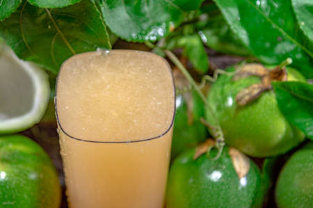 fresh and frozen passion fruit juice. Green fruits. Leaves on wooden background. healthy drink. tropical fruit cocktail. Refreshing drink. natural drink. fruit juice.の写真素材