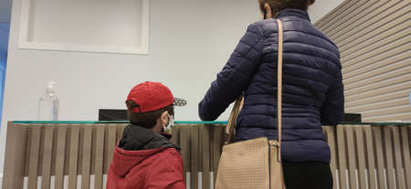 Mother and son. H1N1 vaccine clinic. Face protection masks against Covid-19. Preventive and family medicine clinic. Medical care network in Brazil. Immunization. Pandemicのeditorial素材