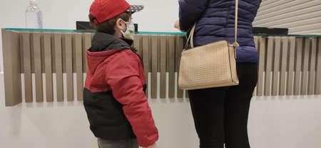Mother and son. H1N1 vaccine clinic. Face protection masks against Covid-19. Preventive and family...