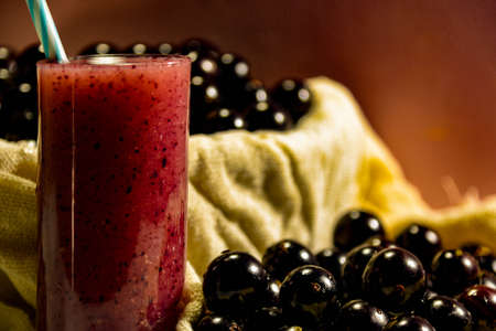 Fresh fruit and glass of jaboticaba juice. Jabuticaba is a fruit originally from Brazil. Native to the Atlantic Forest, it has the unusual characteristic of sprouting on the stem and not on its flowers.の写真素材