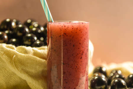 Fresh fruit and glass of jaboticaba juice. Jabuticaba is a fruit originally from Brazil. Native to the Atlantic Forest, it has the unusual characteristic of sprouting on the stem and not on its flowers.の写真素材