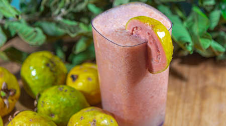 Guava's juice. A sparkling glass of yellow-green guava juice. Organic background. Natural drink. Detox juice. Tropical fruit drink. Drink for slimming and body health.の写真素材