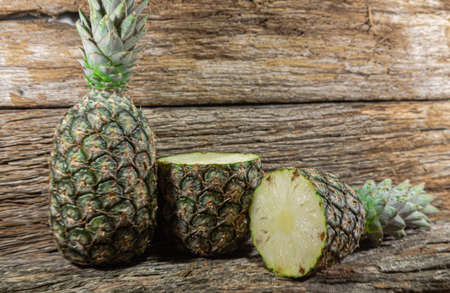 Pineapple fruit. Pineapple in halves. Detox diet. Plant for juices. Tropical fruits. Natural food and detox. Pineapple on wooden background. Tropical plant. King fruit.の写真素材