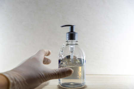 Alcohol gel and glove against Covid-19. Infectious disease caused by the coronavirus of severe acute respiratory syndrome 2 (SARS-CoV-2). Symptoms are fever, cough and difficulty breathing.の写真素材