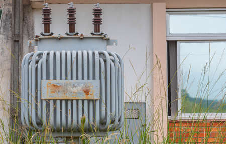 Electricity transformer in abandoned house. Energetic equipment. Electricity distribution infrastructure. Voltage transformer.の写真素材